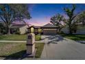 Charming home featuring a manicured lawn, mature trees, and a two-car garage, creating a welcoming curb appeal at 1728 Elk Spring Dr, Brandon, FL 33511