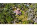 Aerial view of sprawling home on wooded lot with fenced yard, large deck for outdoor living, and mature trees at 22259 Skyview Cir, Brooksville, FL 34602