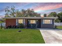 Beautiful single-Gathering home with landscaped garden, white shutters, and cozy seating on the front porch at 27 Park Ave, Tarpon Springs, FL 34689