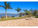 Brick patio featuring lawn chairs and views of the waterfront and tropical landscaping at 3399 Maple Ne St, St Petersburg, FL 33704