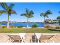 Waterfront patio featuring lounge chairs and views of the blue water and palm trees at 3399 Maple Ne St, St Petersburg, FL 33704