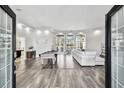 Elegant living room featuring dark wood floors, a billiard table, recessed lighting, and large windows at 3844 Wellington Pkwy, Palm Harbor, FL 34685