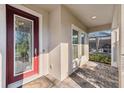 Inviting front porch with decorative front door and views of the screened-in pool at 4195 Welling Ter, Land O Lakes, FL 34638