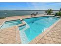 Inviting pool with an attached hot tub and steps leading into the pool with two chairs on the dock at 447 22Nd St, Belleair Beach, FL 33786