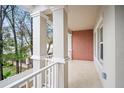 View of the balcony with white railings and columns plus an exposed brick wall at 4511 S Manhattan Ave # 18, Tampa, FL 33611