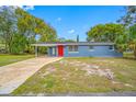 A charming blue house with a vibrant red door and a spacious front yard at 6232 Jackson St, New Port Richey, FL 34653