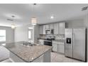 A modern kitchen with stainless steel appliances, granite countertops, and pendant lighting above the island at 7608 Broad Pointe Dr, Zephyrhills, FL 33540