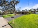 Inviting home exterior with well-manicured lawn and a driveway leading to a covered carport at 8713 W Lanway Dr, Tampa, FL 33637