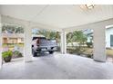Carport showcases ample space for vehicle parking, with views of palm trees and nearby greenery at 1015 Harefield Cir, Sun City Center, FL 33573