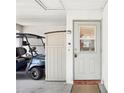 Welcoming home entrance featuring a golf cart, side storage and a secure front door at 1015 Harefield Cir, Sun City Center, FL 33573
