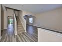 Spacious living room with stylish wood flooring, staircase, and plenty of natural light at 10730 Shady Preserve Dr, Riverview, FL 33579