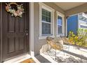 Inviting front porch area with modern seating, a decorative wreath, and a welcoming entrance at 11421 Quiet Forest Dr, Tampa, FL 33635