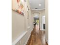 Elegant hallway featuring hardwood floors, decorative wall art, and recessed lighting at 11421 Quiet Forest Dr, Tampa, FL 33635