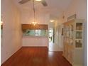 Open dining room featuring wood floors, breakfast bar, and a ceiling fan at 11511 113Th St # 36B, Largo, FL 33778