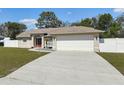 Exterior shot showcasing a two-car garage, concrete driveway, and well-kept lawn of the property at 14129 Prospect St, Spring Hill, FL 34609