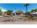 Inviting one-story home with a decorative front entrance, front lawn with palm trees, and blue skies at 15417 2Nd E St, Madeira Beach, FL 33708