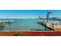 Scenic waterfront with a dock and serene views of the open water with cityscape in the distance at 15417 2Nd E St, Madeira Beach, FL 33708