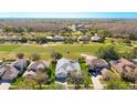 Stunning aerial view of a home nestled within a golf course community, surrounded by lush greenery and water features at 18111 Diamond Cove Ct, Tampa, FL 33647