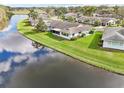 Beautiful aerial view of home on waterfront property with lush green lawn and screened lanai at 2022 Heathfield Cir, Sun City Center, FL 33573