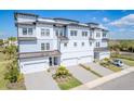 Stunning aerial view of a three-story townhome with private garages, manicured landscaping, and stylish architecture at 3025 Bermuda Sloop Cir, Ruskin, FL 33570
