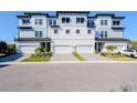Contemporary three-story townhome boasts attached garages and attractive landscaping at 3025 Bermuda Sloop Cir, Ruskin, FL 33570
