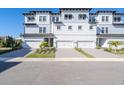 Stylish three-story townhome showcasing individual garages, elegant curb appeal, and modern design at 3025 Bermuda Sloop Cir, Ruskin, FL 33570