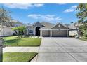 Charming home with a meticulously maintained lawn, complemented by a long driveway and an attached garage at 3537 Valencia Cove Court, Land O Lakes, FL 34639