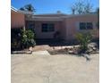 Charming single-story home with a vibrant pink exterior, front yard landscaping, and brick walkway at 3800 Belle Vista E Dr, St Pete Beach, FL 33706