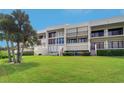 Modern condo building with an inviting balcony, and lush green lawn at 50 Coe Rd # 223, Belleair, FL 33756