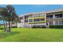 Modern condo building with an inviting balcony, and lush green lawn at 50 Coe Rd # 223, Belleair, FL 33756