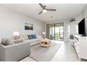 Cozy living room with neutral colors and a sliding glass door to the outdoors at 5514 Tidal Breeze Cv, Bradenton, FL 34211