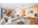 Inviting living room features a white sofa, art, and a marble-patterned coffee table on hardwood floors at 6445 109Th N Ave, Pinellas Park, FL 33782