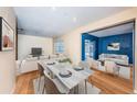 Bright and airy living area with wood floors and an open layout flowing into the cozy blue Gathering room at 6445 109Th N Ave, Pinellas Park, FL 33782