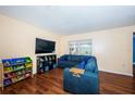 Bright living room featuring a comfortable sectional sofa, sleek wood floors, and a window, creating a cozy space at 6445 109Th N Ave, Pinellas Park, FL 33782
