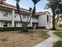 Condo building exterior showcasing second story units, white railings, and mature landscaping at 6815 Dali Ave # F101, Land O Lakes, FL 34637
