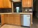 Kitchen featuring stainless steel dishwasher, light wood cabinets, and granite countertops at 6815 Dali Ave # F101, Land O Lakes, FL 34637