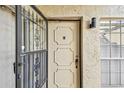 Close-up of the front door with decorative details, security screen, and exterior sconce at 7200 Ulmerton Rd # B4, Largo, FL 33771