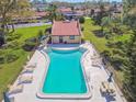 Aerial view of the community pool, surrounded by lounge chairs and manicured landscaping at 7200 Ulmerton Rd # B4, Largo, FL 33771