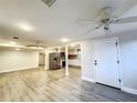 Open floor plan living room leading to kitchen, with new flooring and modern ceiling fans at 11201 Blendale Dr, Riverview, FL 33569