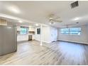 Open floor plan living room leading to kitchen, with new flooring and modern ceiling fans at 11201 Blendale Dr, Riverview, FL 33569