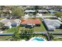 An aerial view of a single-Gathering home with a backyard pool surrounded by tropical landscaping at 1450 Highfield Dr, Clearwater, FL 33764