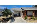View of the brick home's attached carport and front entrance at 1507 N Lake Dr, Sun City Center, FL 33573