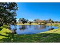 Scenic view of a serene pond surrounded by lush greenery and trees on a sunny day at 2210 Gulf View Blvd # 22, Dunedin, FL 34698