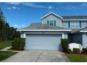Charming home featuring a two-car garage, complemented by well-maintained landscaping and bright blue shutters at 284 Hemingway Dr, Oldsmar, FL 34677