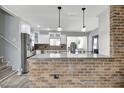 Modern kitchen featuring white cabinets, stainless steel appliances, and a brick-accented breakfast bar at 4716 Gazania St, New Port Richey, FL 34652