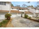 Charming townhome featuring white siding, a brown roof, attached garage and a well-maintained driveway at 5203 Bayshore Blvd # 5, Tampa, FL 33611
