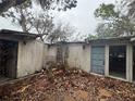 Exterior of a weathered home, showing its potential for renovation and restoration, set in an overgrown yard at 5218 Winding Way, Sarasota, FL 34242