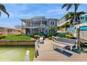 Waterfront home with dock, spiral staircase, balcony, and lush landscaping at 750 123Rd Ave, Treasure Island, FL 33706