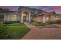 Charming two-story home featuring a beautiful tile roof, arched entryway, and well-manicured landscaping at 7888 Lantana Creek Rd, Largo, FL 33777