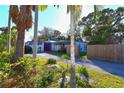The front exterior of a home shows a manicured yard and a red front door at 7990 42Nd N St, Pinellas Park, FL 33781
